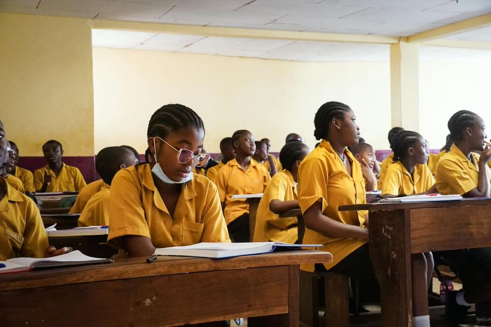 Student with glasses reading at her desk in a NESCAS classroom