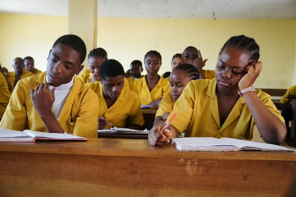 Students in yellow uniforms studying at their desks
